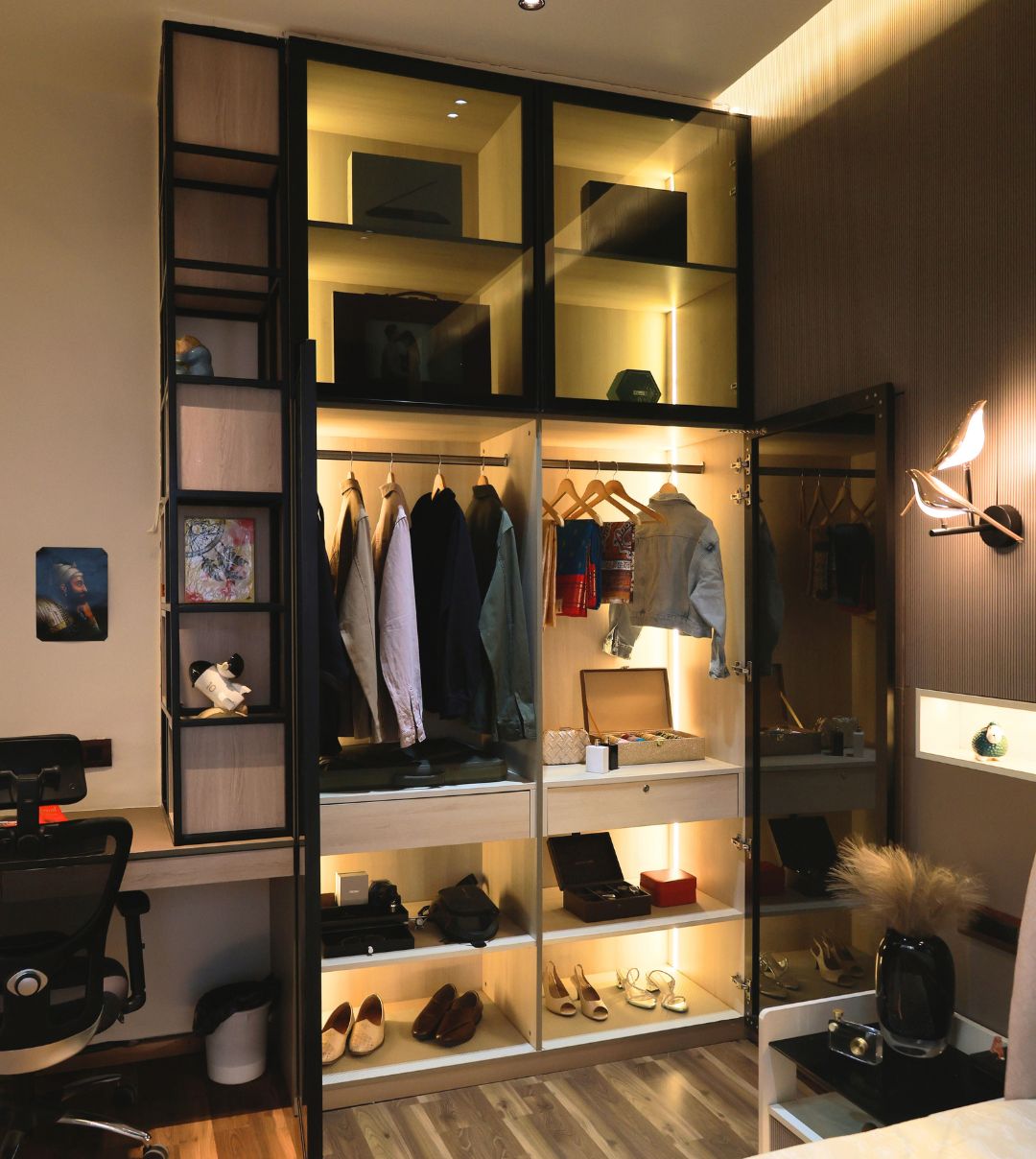 Open wardrobe with lit shelves and hanging clothes